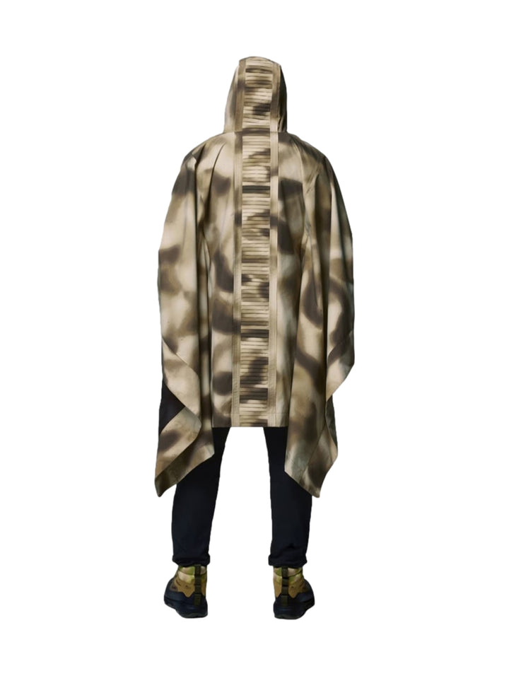 Dos personas vistiendo un poncho Columbia con estampado de camuflaje en tonos beige y marrón con capucha.