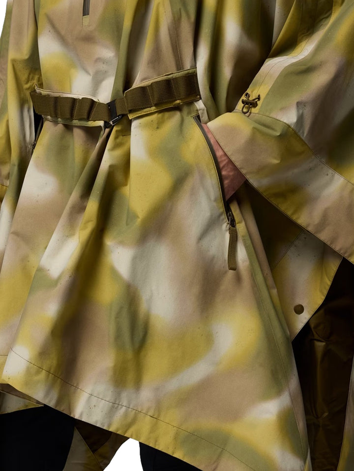Hombre y mujer vistiendo un poncho Columbia con estampado de camuflaje verde y cinturón ajustable.