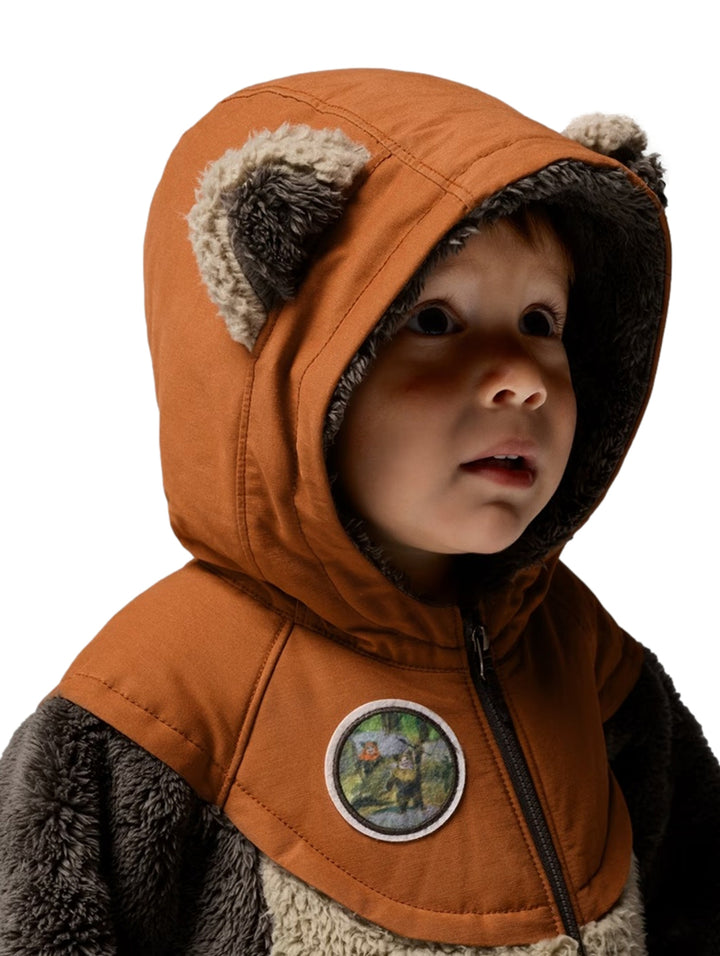 Niño con chamarra Columbia de polar marrón y beige con capucha y orejas de oso.