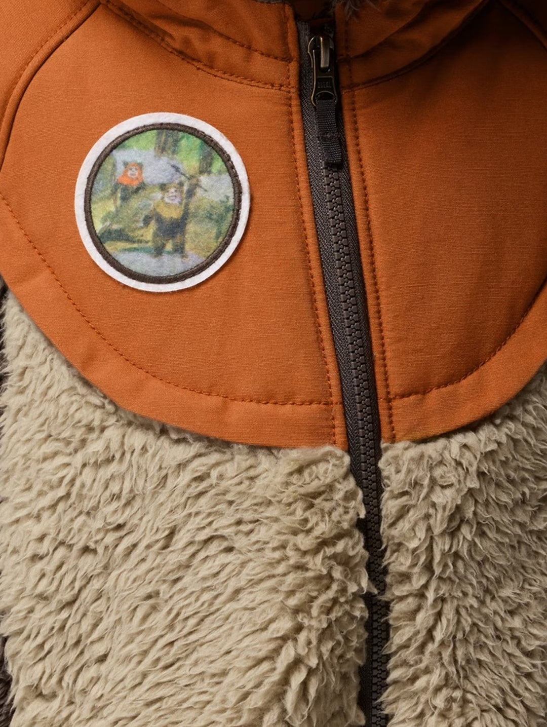 Niño con chamarra Columbia de polar marrón y beige con capucha y orejas de oso.