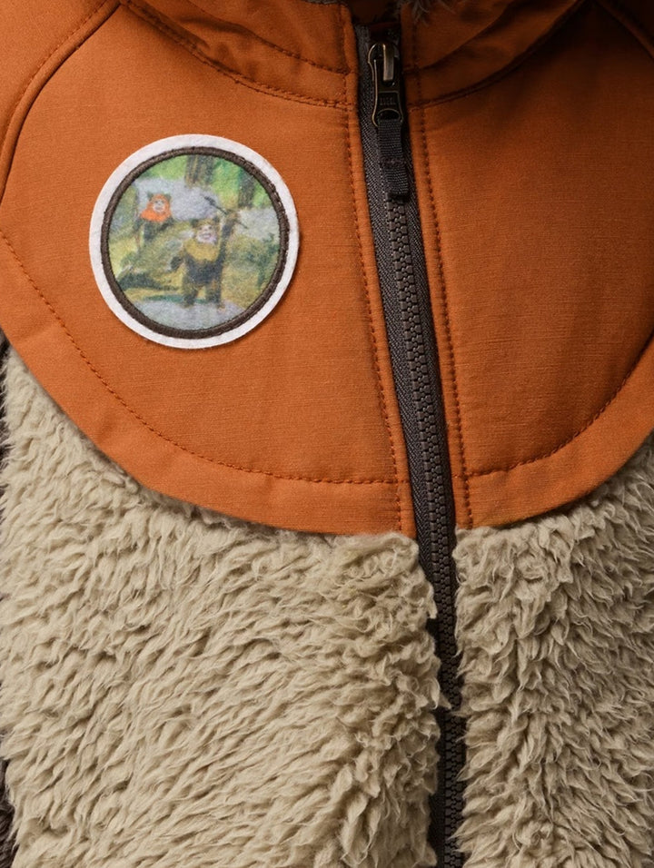 Niño con chamarra Columbia de polar marrón y beige con capucha y orejas de oso.