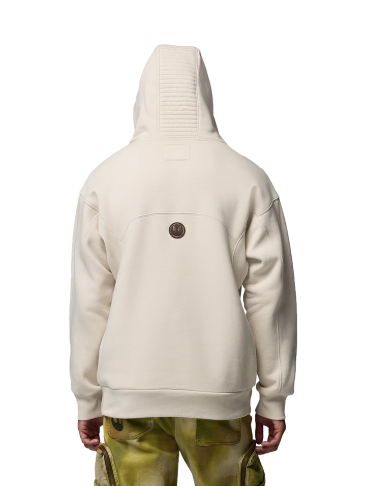 Sudadera con capucha color fawn con gráfico frontal, mostrada en modelos hombre y mujer.