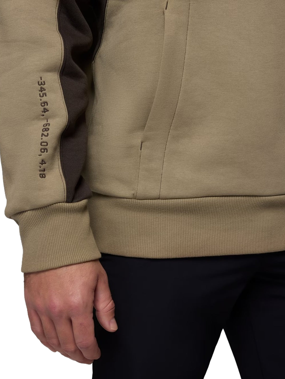 Hombre y mujer vistiendo sudaderas con capucha Columbia color khaki con detalles en marrón oscuro y gráfico frontal.