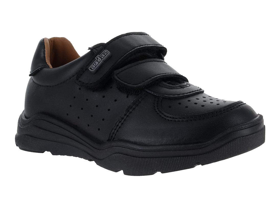 Zapato infantil color negro con cierre de velcro y detalles perforados en el costado y punta.