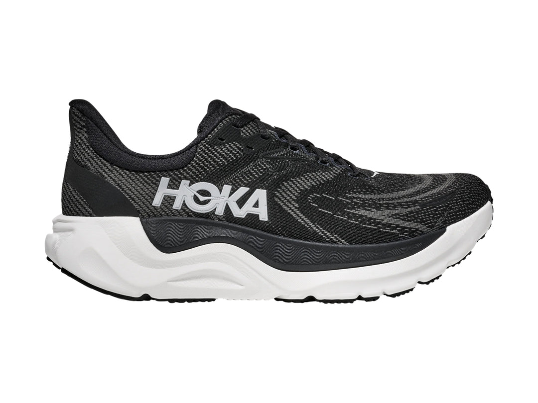 Tenis deportivos HOKA Arahi 8 en color negro con suela blanca y logotipo lateral blanco.