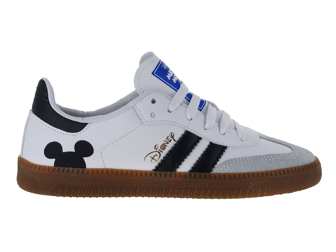 Tenis deportivos blancos con detalles en negro, suela marrón y diseño de Mickey Mouse.