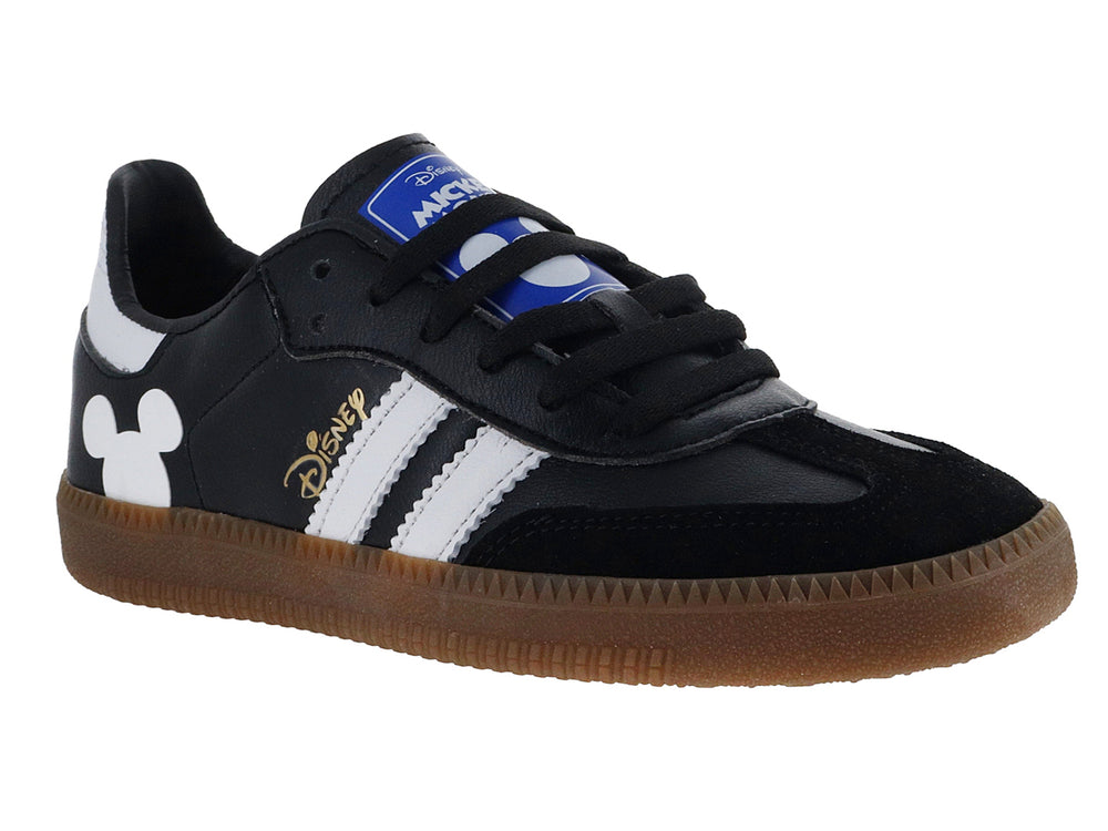 Tenis negros DTX con suela café, rayas blancas laterales y silueta de Mickey Mouse en el talón.