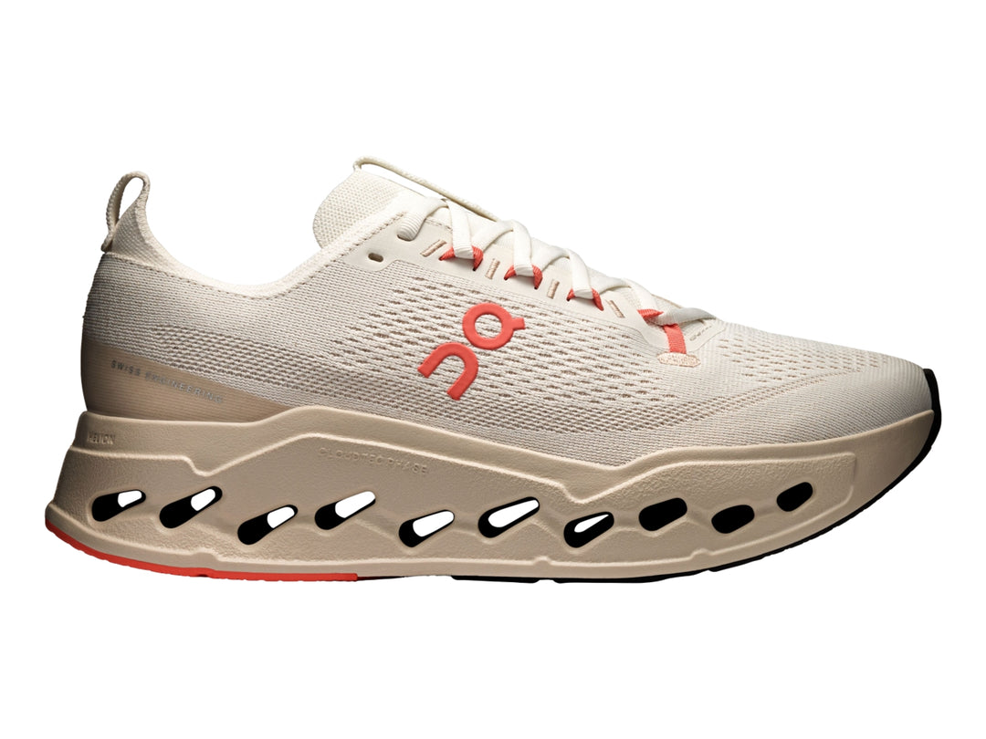 Tenis deportivos On Cloudsurfer Max color ivory con detalles en salmon y suela amortiguada.