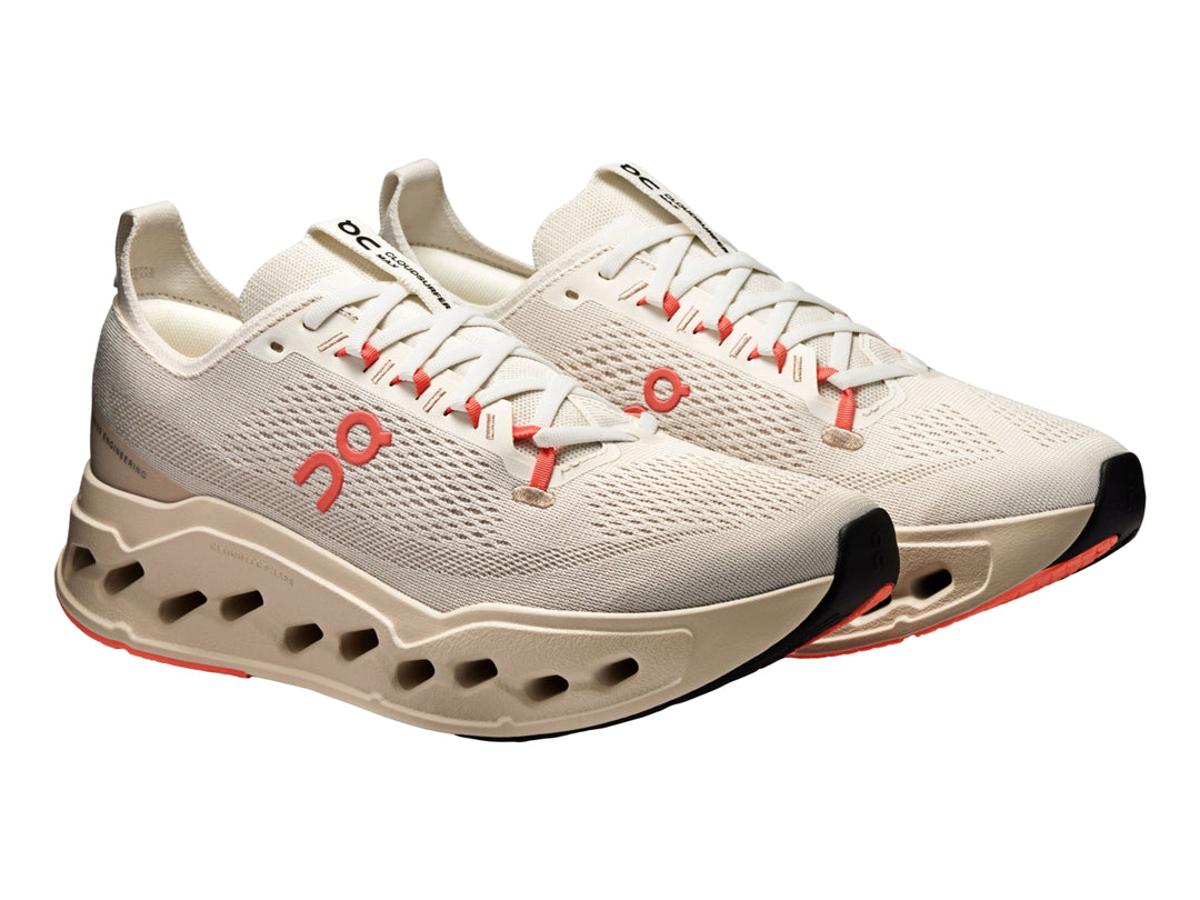 Tenis deportivos On Cloudsurfer Max color ivory con detalles en salmon y suela amortiguada.