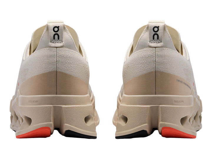 Tenis deportivos On Cloudsurfer Max color ivory con detalles en salmon y suela amortiguada.