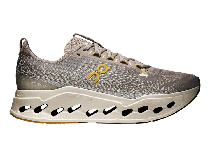 Tenis deportivos On Cloud Cloudsurfer Max color gris marrón con suela gruesa color crema.