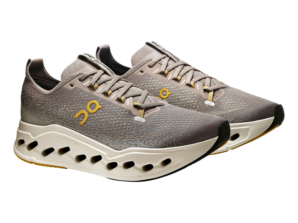 Tenis deportivos On Cloud Cloudsurfer Max color gris marrón con suela gruesa color crema.