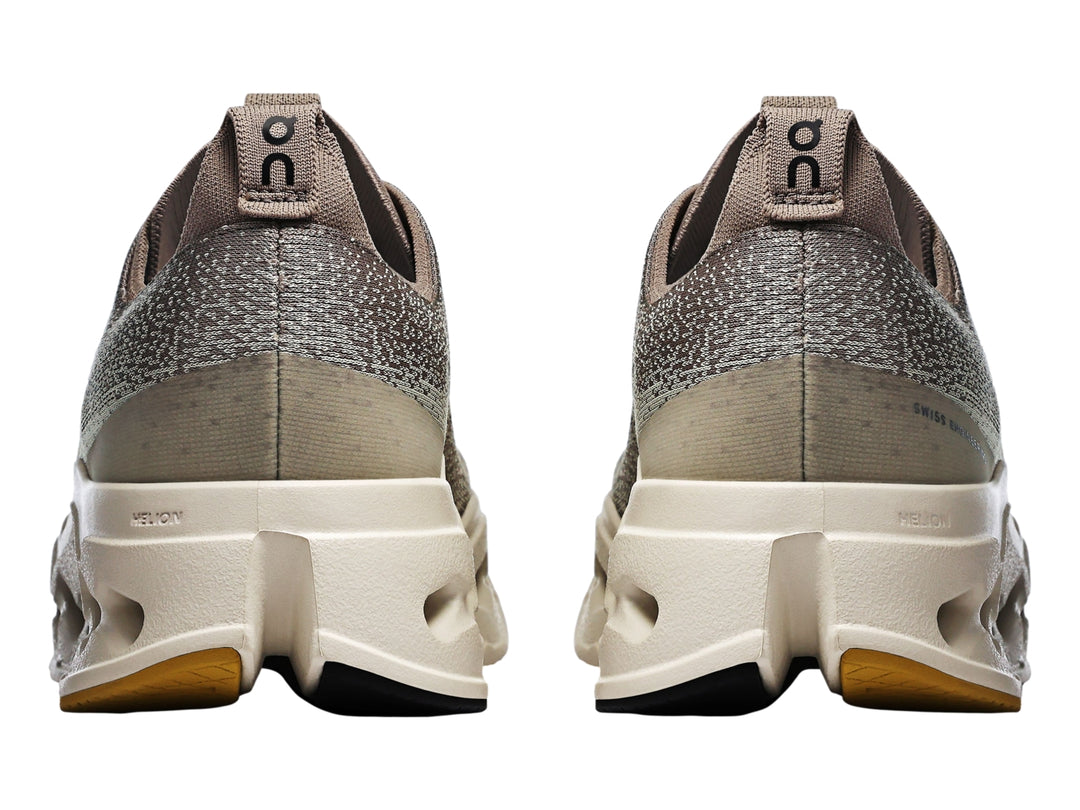 Tenis deportivos On Cloud Cloudsurfer Max color gris marrón con suela gruesa color crema.