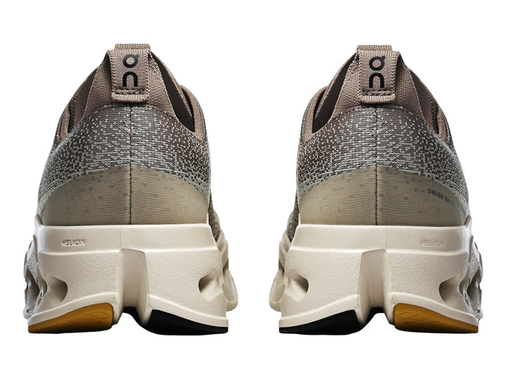 Tenis deportivos On Cloud Cloudsurfer Max color gris marrón con suela gruesa color crema.