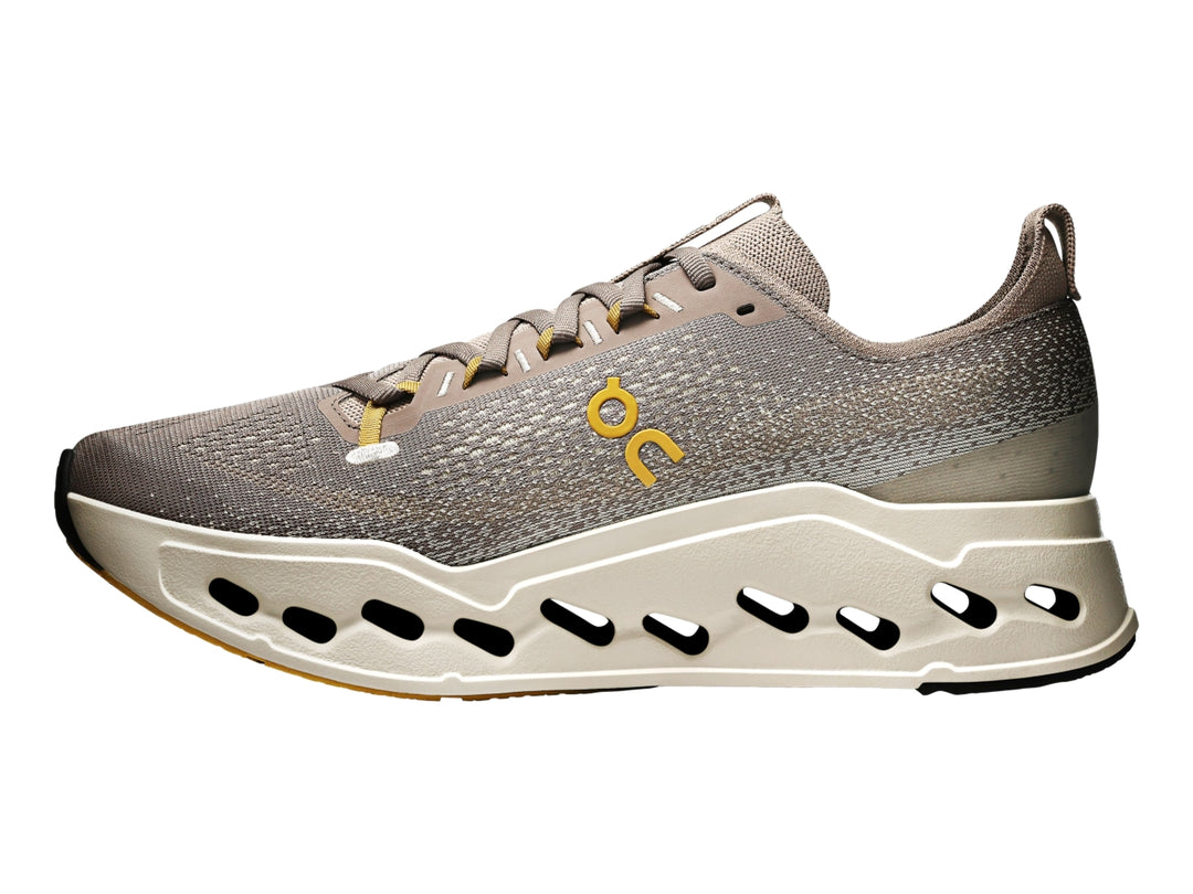 Tenis deportivos On Cloud Cloudsurfer Max color gris marrón con suela gruesa color crema.