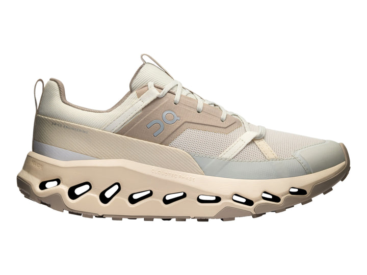 Tenis deportivos On Cloud en color beige y blanco con suela característica de cápsulas huecas.