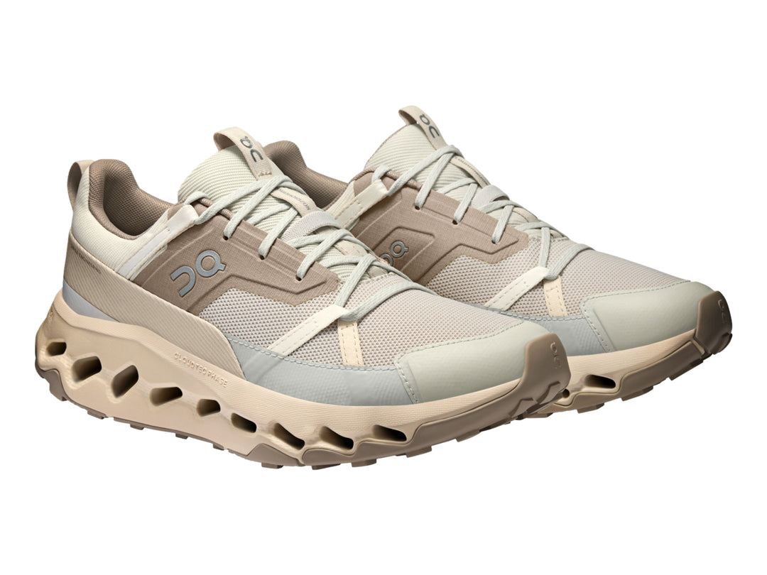 Tenis deportivos On Cloud en color beige y blanco con suela característica de cápsulas huecas.