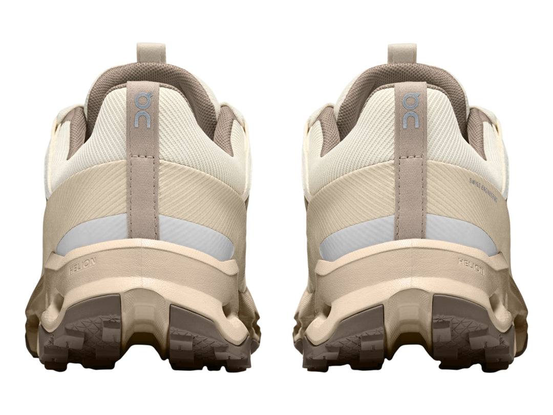Tenis deportivos On Cloud en color beige y blanco con suela característica de cápsulas huecas.