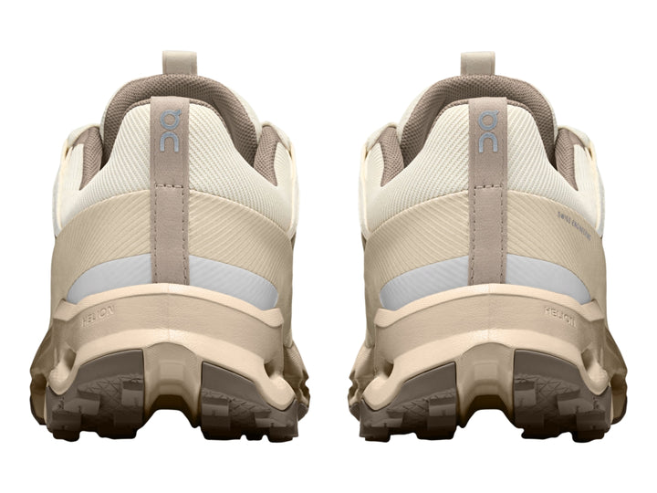 Tenis deportivos On Cloud en color beige y blanco con suela característica de cápsulas huecas.