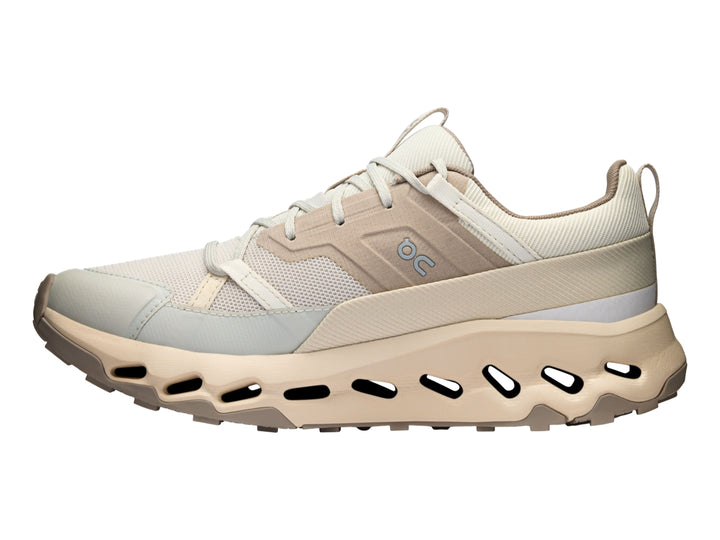 Tenis deportivos On Cloud en color beige y blanco con suela característica de cápsulas huecas.