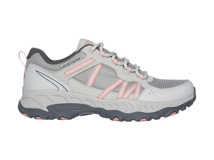 Tenis deportivos Skechers color gris con detalles en rosa y suela robusta.