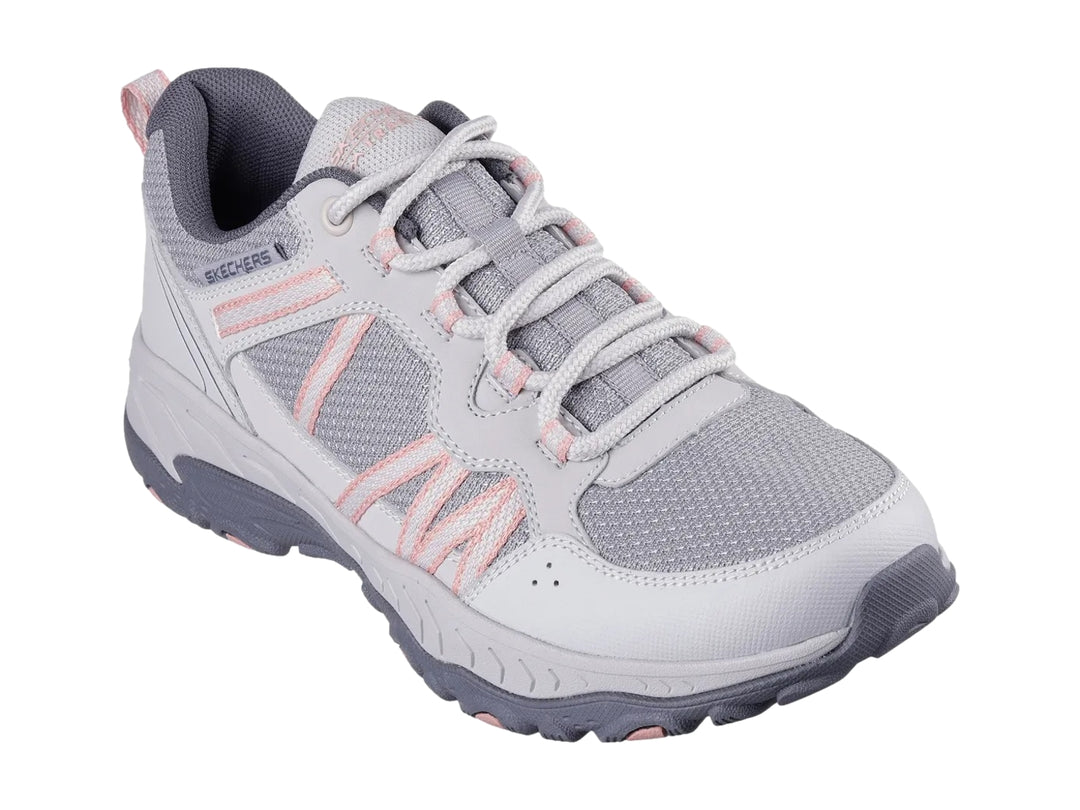 Tenis deportivos Skechers color gris con detalles en rosa y suela robusta.