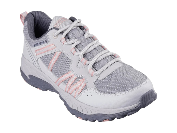Tenis deportivos Skechers color gris con detalles en rosa y suela robusta.