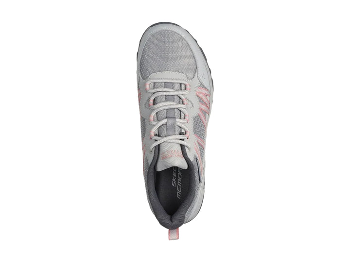 Tenis deportivos Skechers color gris con detalles en rosa y suela robusta.