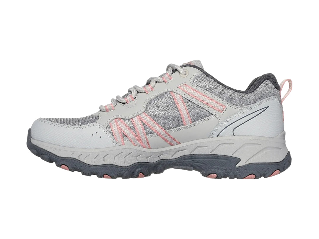 Tenis deportivos Skechers color gris con detalles en rosa y suela robusta.