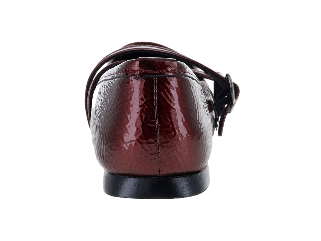 Zapato plano tipo ballerina color vino de charol arrugado con hebillas decorativas.