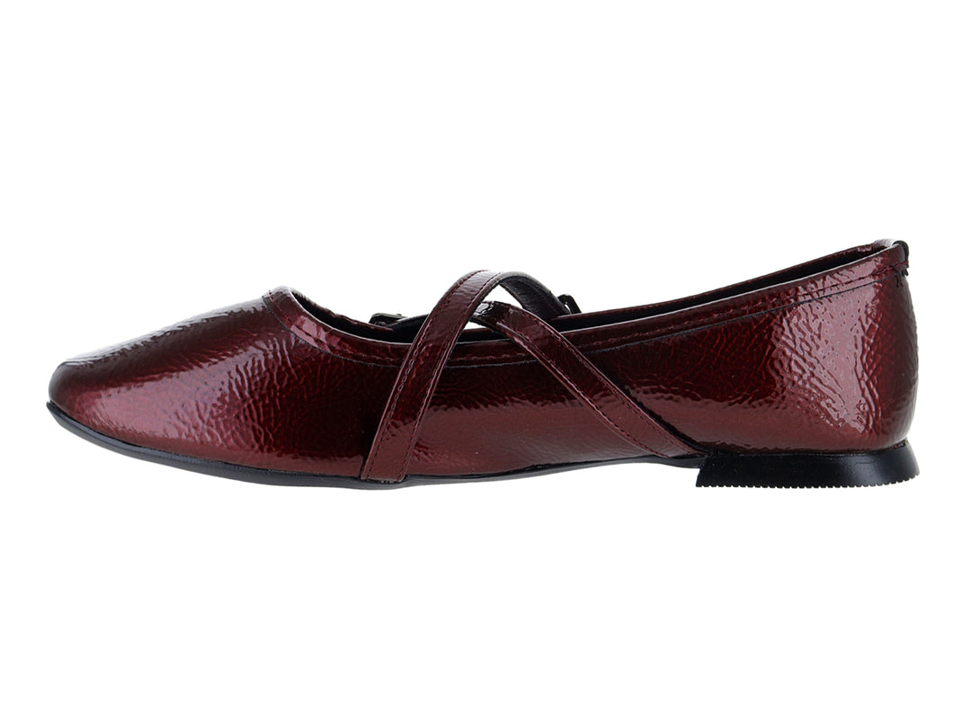 Zapato plano tipo ballerina color vino de charol arrugado con hebillas decorativas.