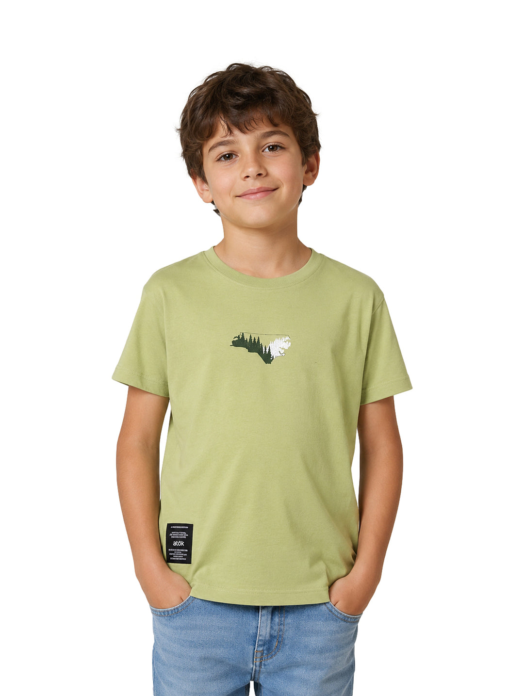Niño vistiendo una camiseta color verde oliva con un pequeño estampado frontal y etiqueta negra en el borde inferior.
