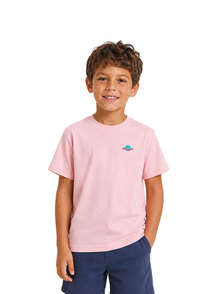 Niño vistiendo una camiseta rosa de manga corta con un pequeño estampado en el pecho.