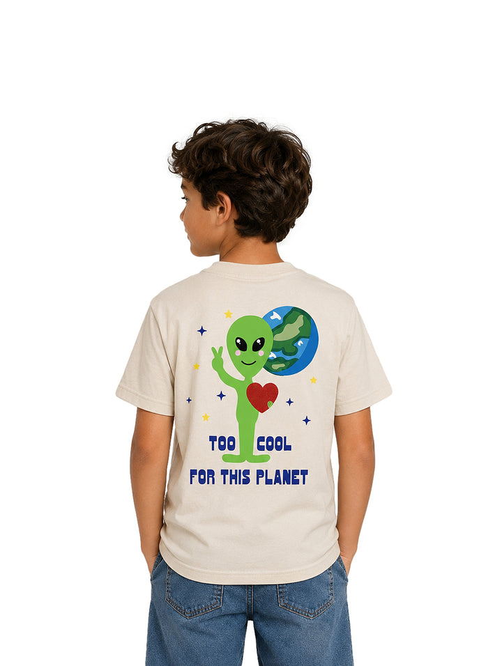 Niño vistiendo camiseta color ivory con un pequeño estampado de alienígena verde en el pecho.