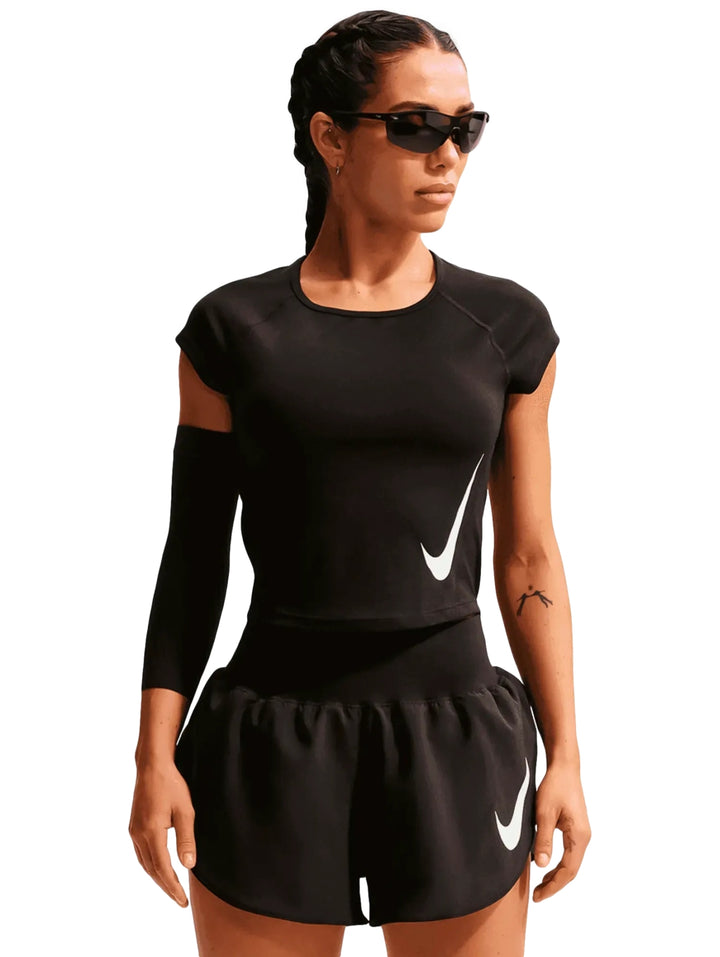 Mujer vistiendo shorts deportivos Nike color negro con logo blanco.