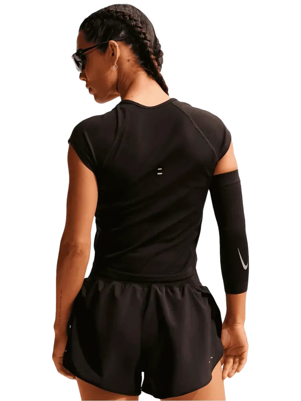 Mujer vistiendo shorts deportivos Nike color negro con logo blanco.