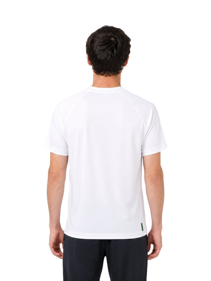 Hombre vistiendo una playera blanca de manga corta de la marca Lacoste con logo en el pecho.