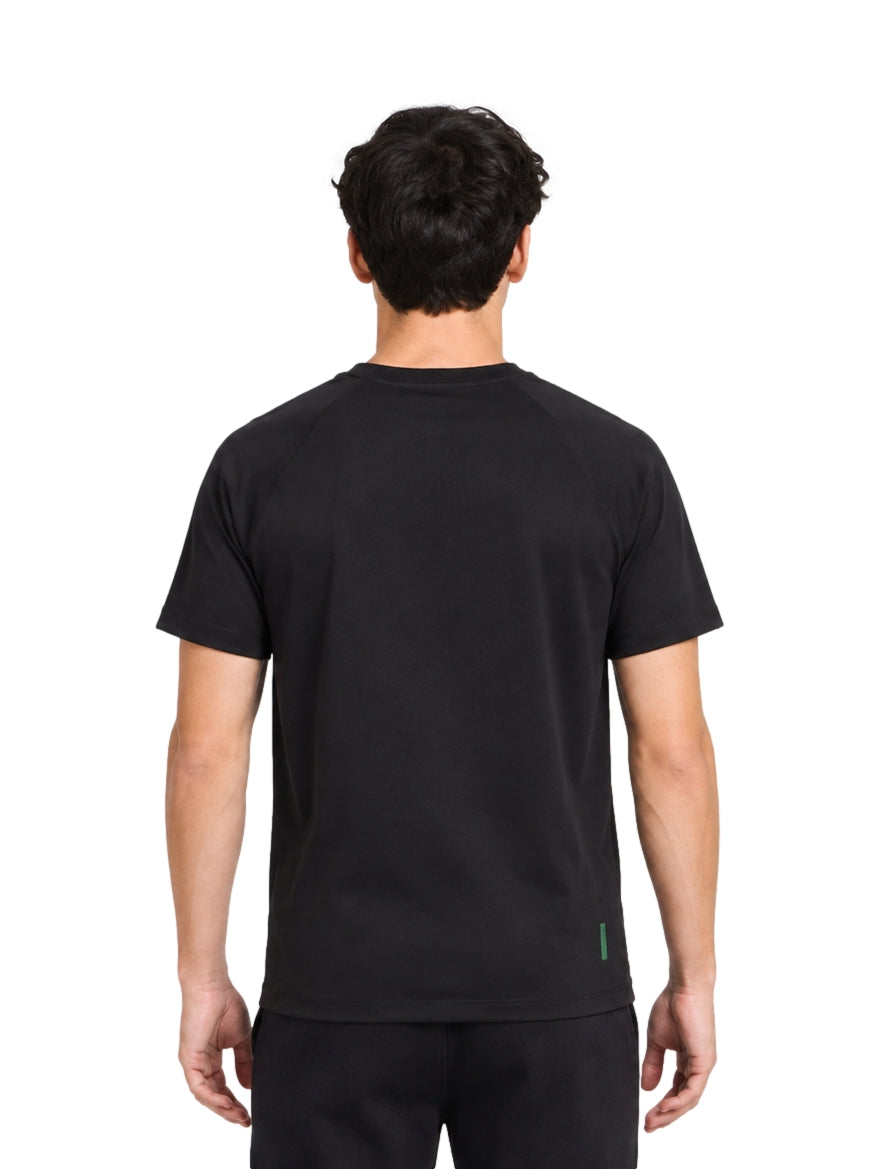 Hombre vistiendo una playera Lacoste de color negro con manga corta y cuello redondo.