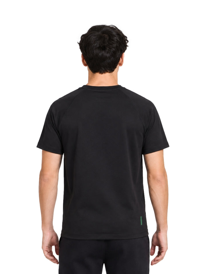 Hombre vistiendo una playera Lacoste de color negro con manga corta y cuello redondo.