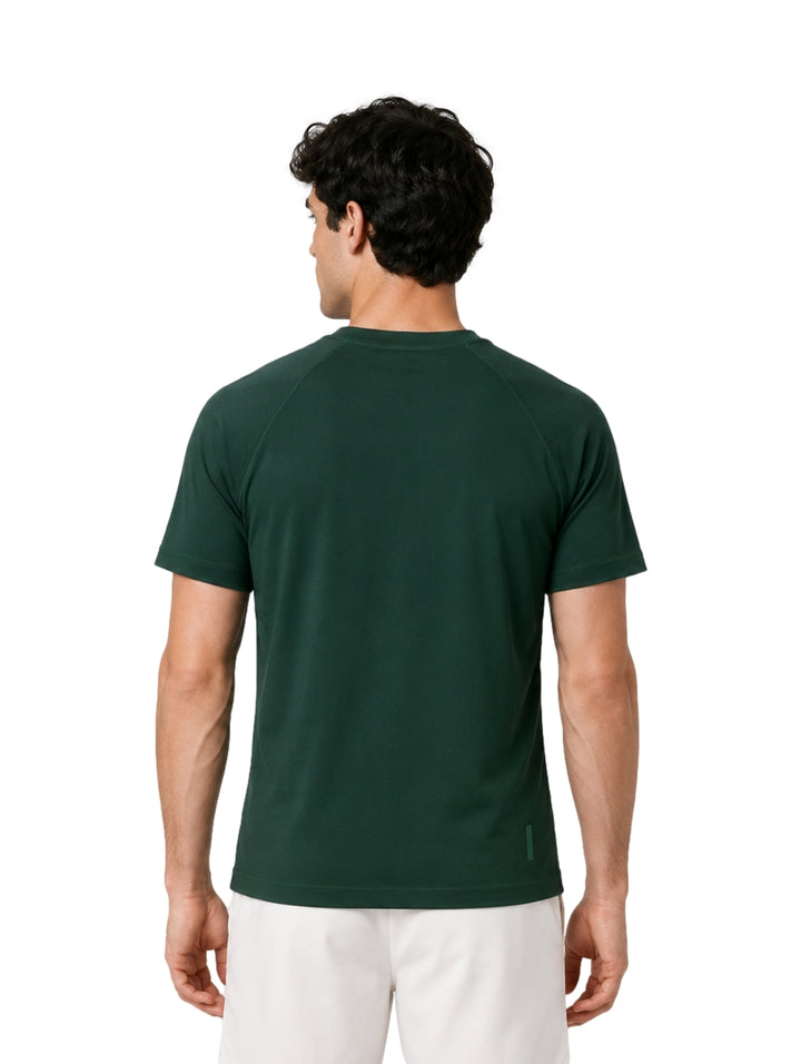 Hombre vistiendo una playera Lacoste de color verde oscuro con cuello redondo y manga corta.