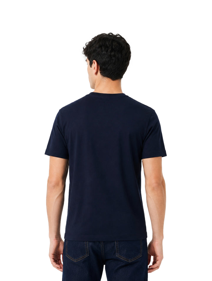 Hombre vistiendo playera Lacoste color navy de manga corta y cuello redondo.