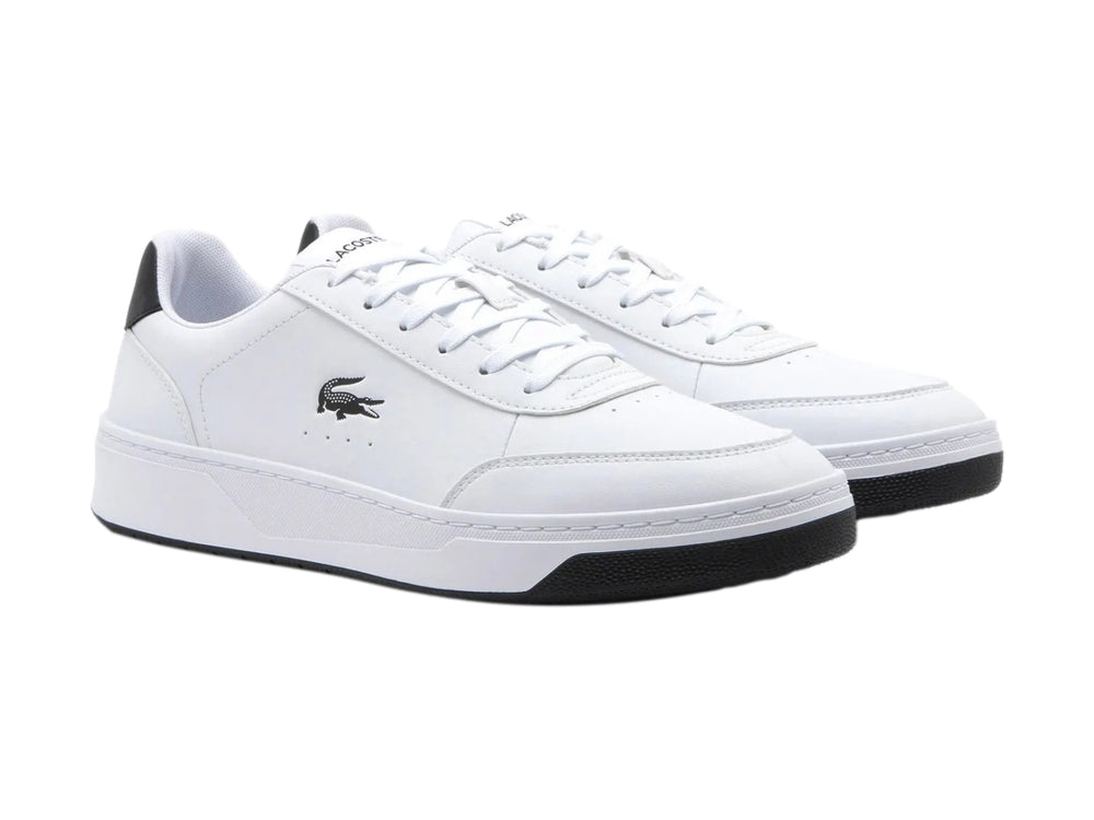 Tenis Lacoste blancos con detalles en negro en el talón y la suela.