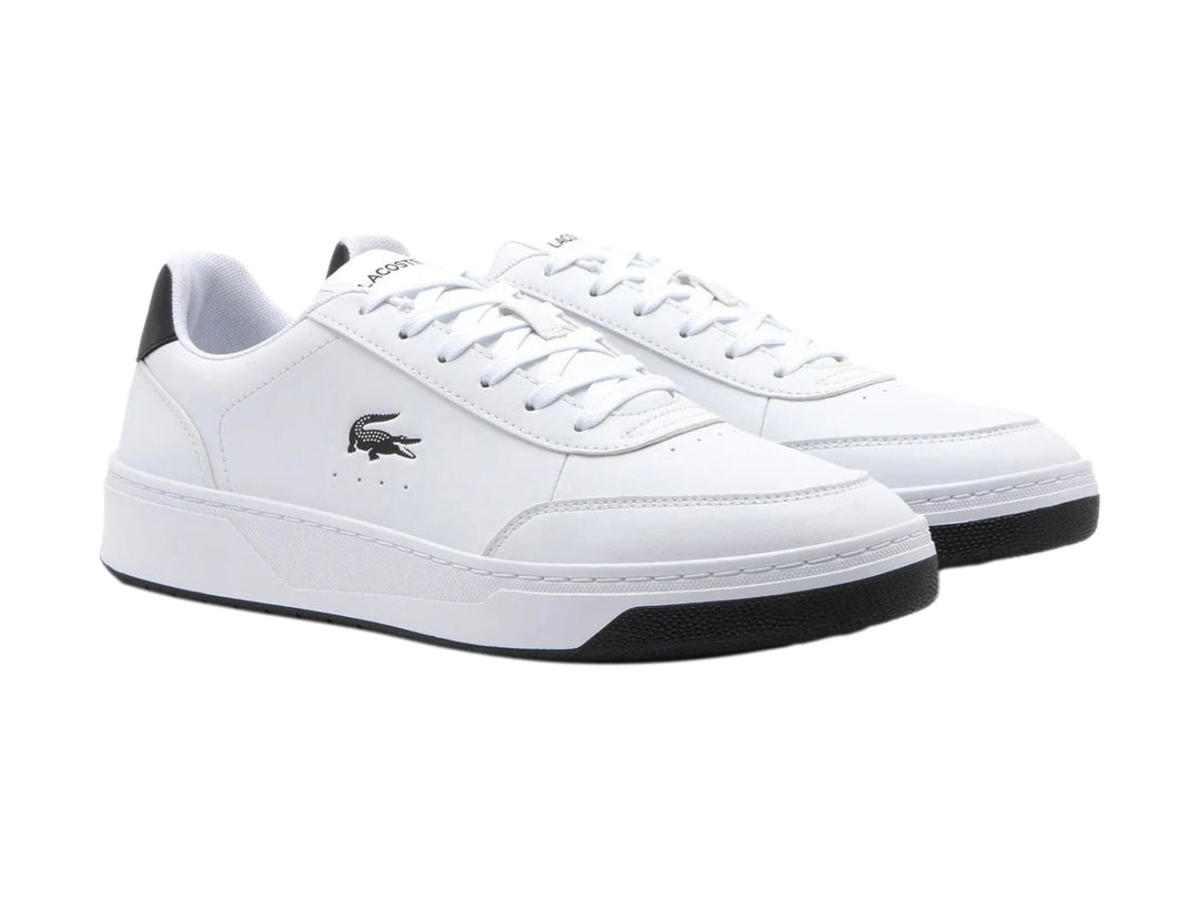 Tenis Lacoste blancos con detalles en negro en el talón y la suela.