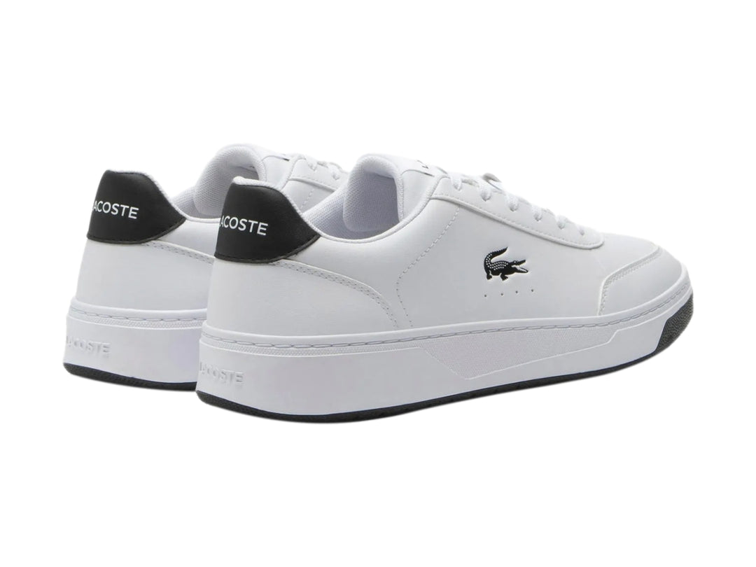Tenis Lacoste blancos con detalles en negro en el talón y la suela.