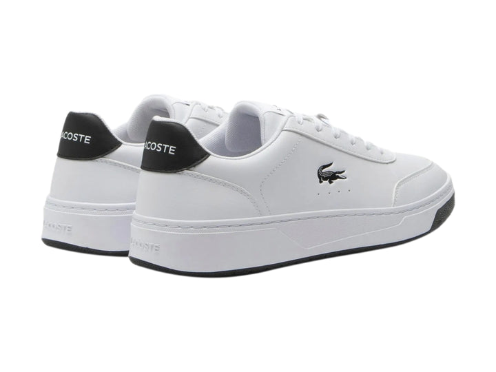 Tenis Lacoste blancos con detalles en negro en el talón y la suela.
