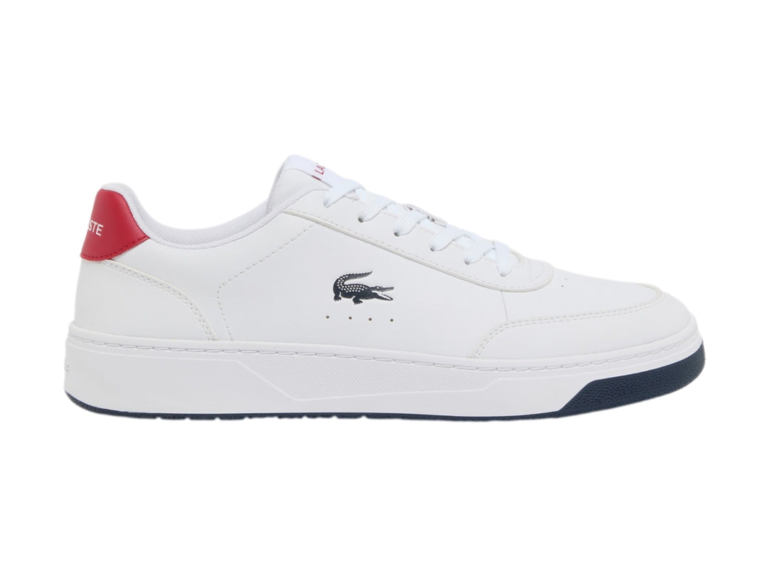 Tenis blancos Lacoste con suela azul marino y detalle rojo en el talón.