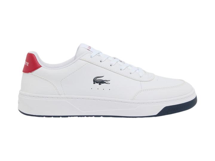 Tenis blancos Lacoste con suela azul marino y detalle rojo en el talón.
