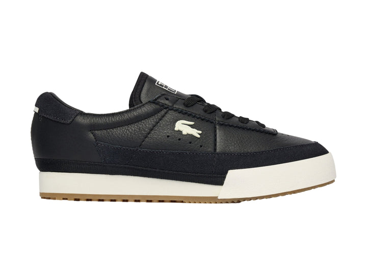 Tenis Lacoste de cuero negro con suela blanca y base de goma marrón.