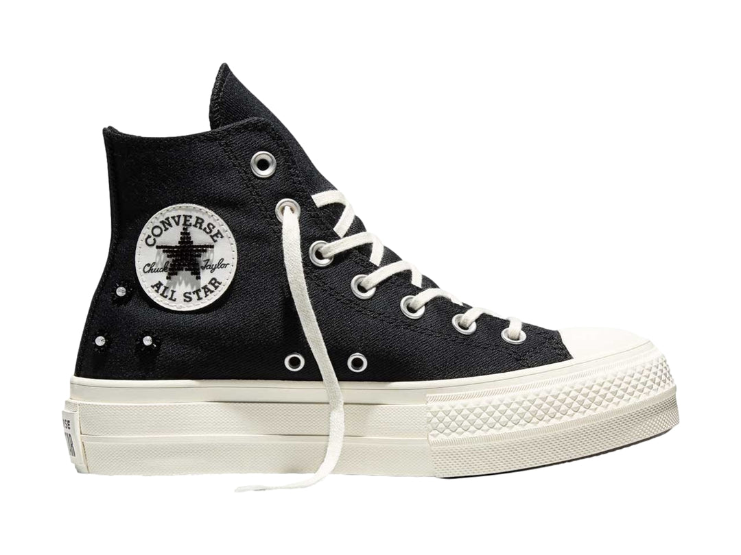Tenis Converse negros de bota alta con suela de plataforma blanca y agujetas blancas.
