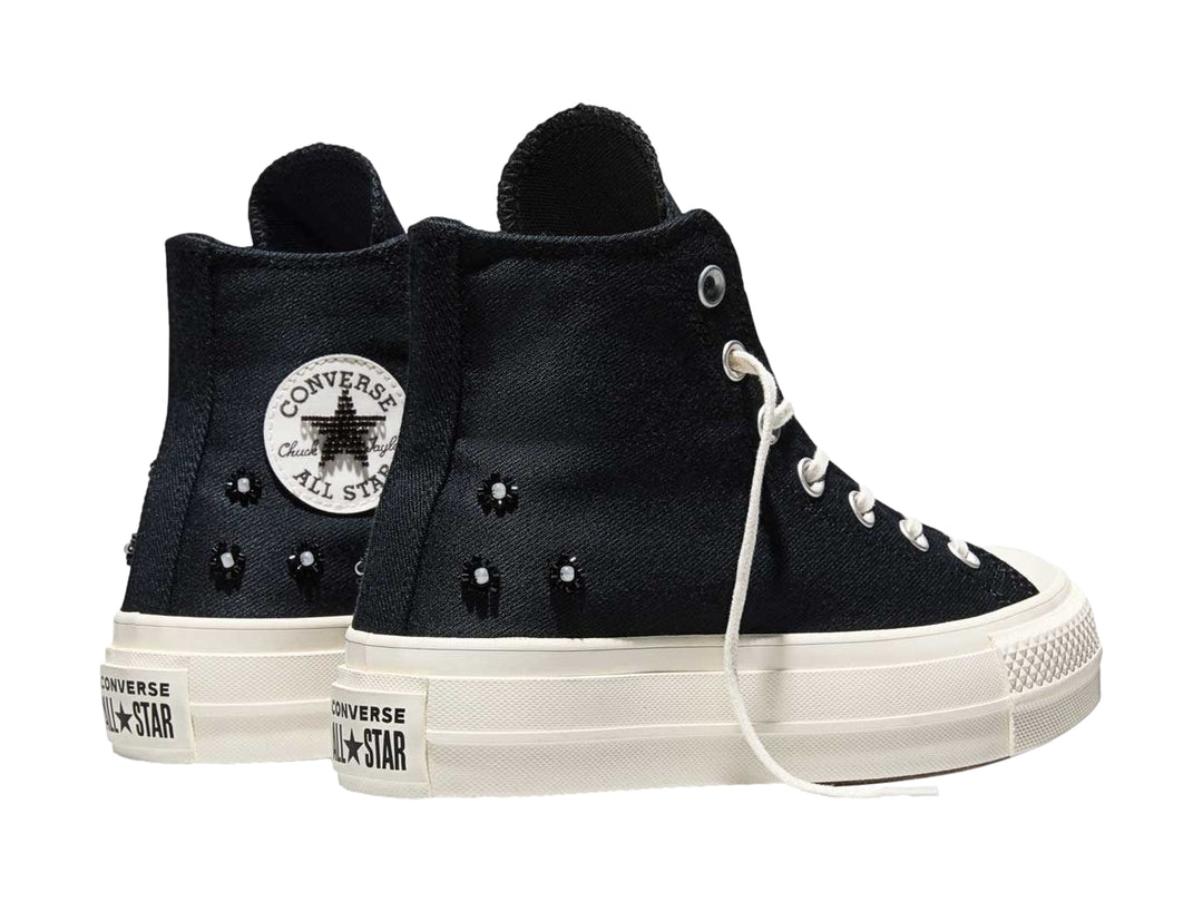Tenis Converse negros de bota alta con suela de plataforma blanca y agujetas blancas.